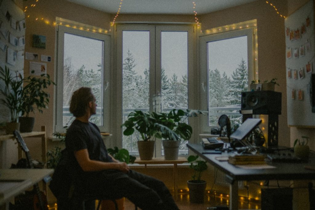 "Person alone by window in quiet reflection"